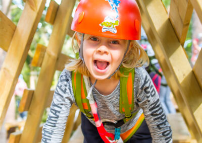 Little girl smiling on a wooden platform in Skypark Vaxholm.