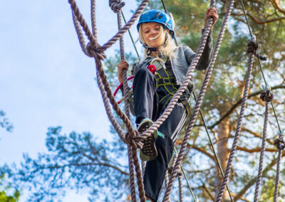 Young girl struggling at a rope hurdle in Skypark Vaxholm.
